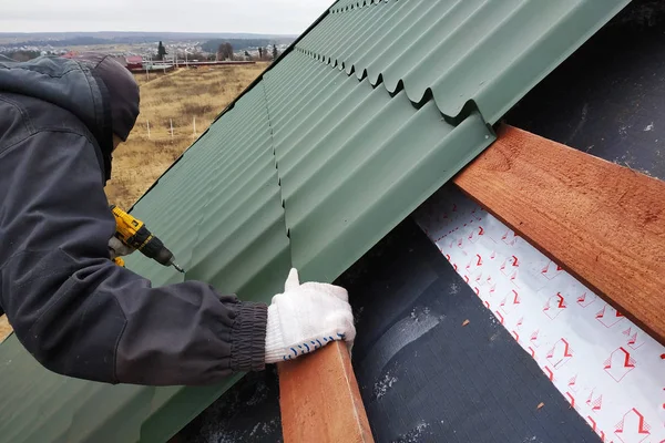 Profesyonel çalışan bir metal kiremit yaprak tarafından bir çatı çatı yüklemesinde çalışır ve bir vida bir matkapla matkaplar — Stok fotoğraf