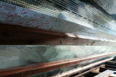 İç Evin çatısı bir sarmalayıcı film ve panoları sabitleme kullanımı ile yalıtım