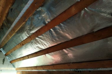 İç Evin çatısı bir sarmalayıcı film ve panoları sabitleme kullanımı ile yalıtım