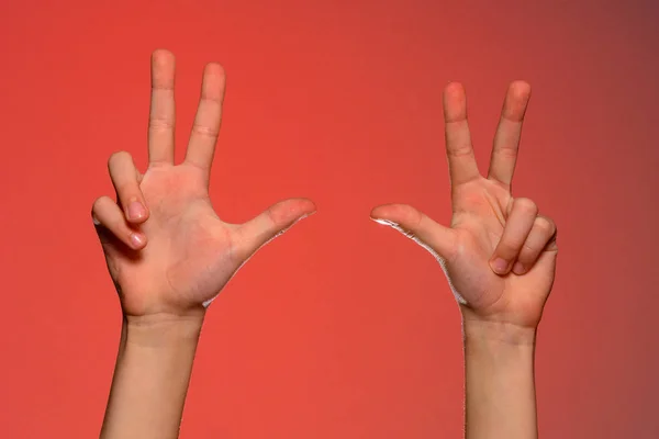 Mano masculina muestra tres dedos aislados sobre fondo rojo — Foto de Stock