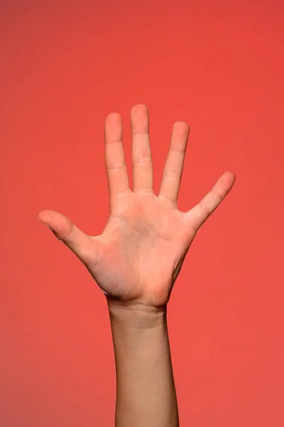 La mano humana muestra cinco dedos, que simboliza el afecto. Aislado sobre un fondo rojo — Foto de Stock