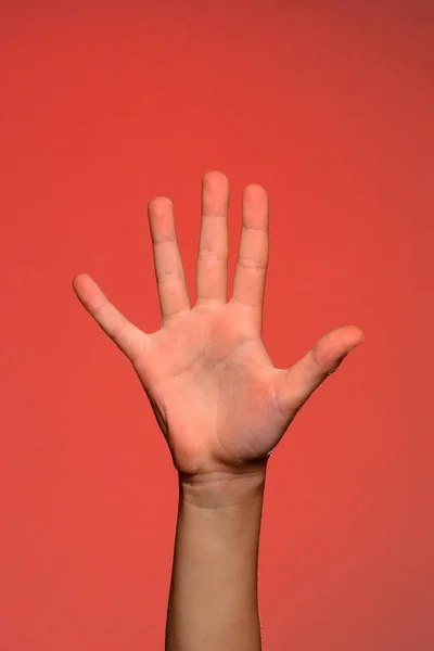 La mano humana muestra cinco dedos, que simboliza el afecto. Aislado sobre un fondo rojo — Foto de Stock