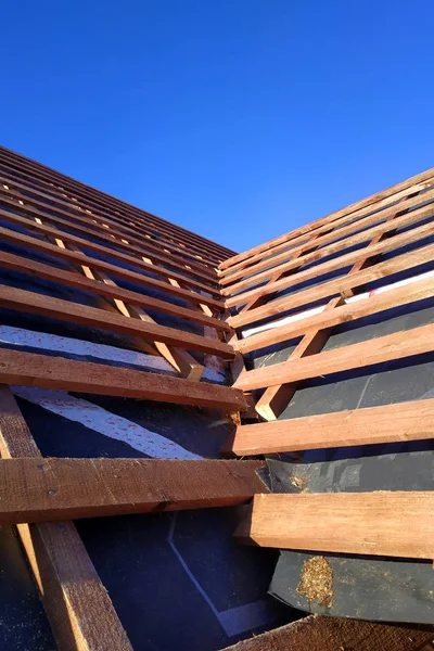 Підготовка даху перед установкою листів металевої плитки з утепленням, гідроізоляцією за допомогою плівки, дощок і брусів — стокове фото
