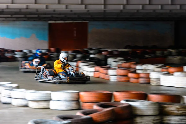 Competição de karting dinâmica em velocidade com movimento desfocado em uma pista de corrida equipada — Fotografia de Stock