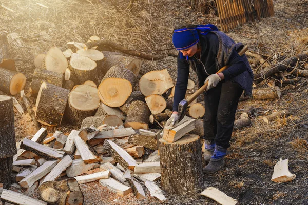 Uma mulher rural atira em uma madeira de freixo para a colheita para o inverno com um machado — Fotografia de Stock