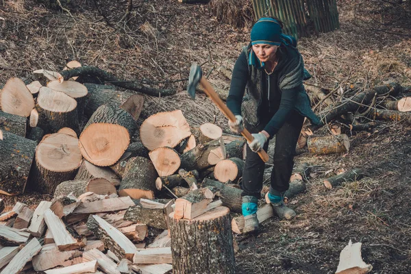 Сільська жінка стріляє попіл деревом для збирання на зиму сокирою — стокове фото
