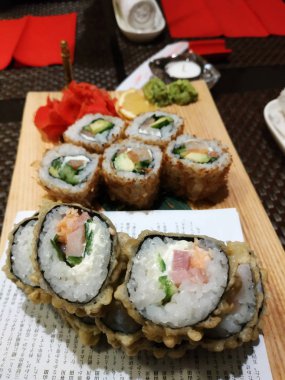 Sıcak suşi marine zencefil ve isabi ile ahşap bir tahta üzerinde servis edilir.