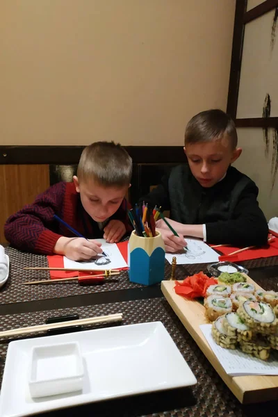 Zwei Brüder malen eine Farbe in die Sushi-Bar. — Stockfoto