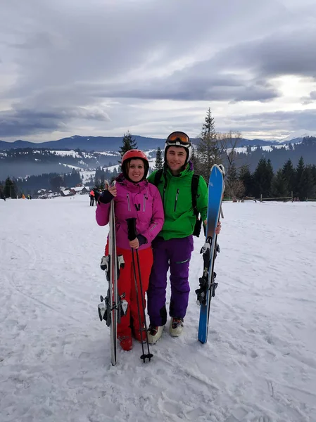 Retrato de un amante de un par de esquiadores en un traje en la cima de las montañas Cárpatos — Foto de Stock