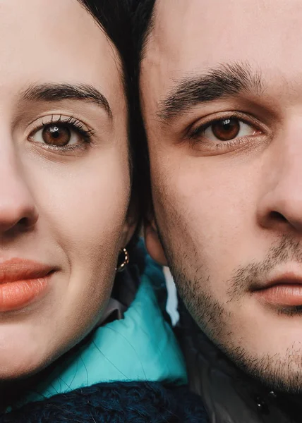 Close up portrait of half faces man and woman looking at camera.