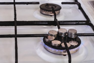 Sikkeler dağınık ve bir gaz sobası üzerinde bir piramit üzerine serilir, gaz yanar.