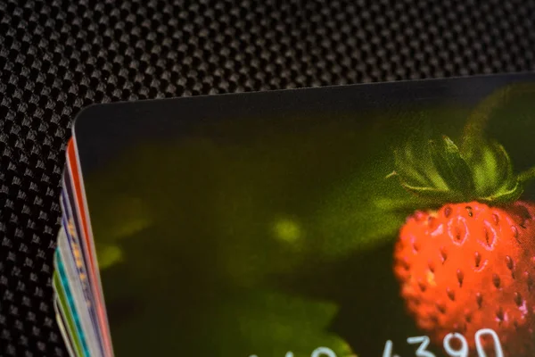 Credit card with beautifully drawn strawberries on a black background.