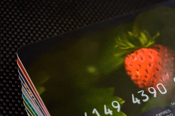 Tarjeta de crédito con fresas bellamente dibujadas sobre un fondo negro . —  Fotos de Stock