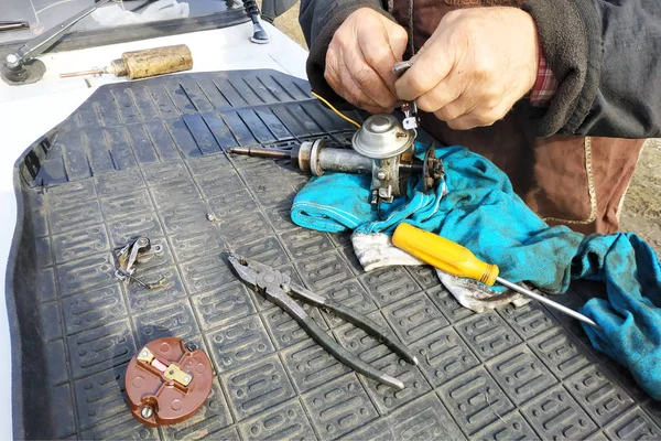 El mecánico del automóvil realiza la reparación del distribuidor de la inflamación del viejo coche de la marca VAZ . —  Fotos de Stock
