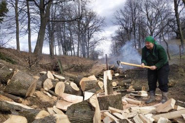 Tavernanın yaşlı bir kadını bahçede baltayla odun sallıyor, onları kışa hazırlıyor..