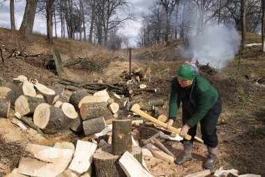 Kış için odun kesen yaşlı bir kadın, aynı zamanda evin yakınındaki bahçesini de kaldırır, ilkbaharın başlarında sokakta..
