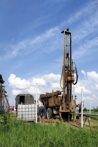 A drill tower on the water in the background of the sky in the countryside. — Stock Photo, Image