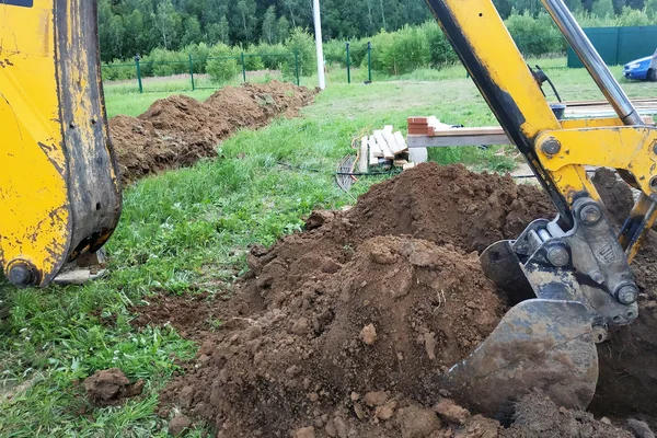 En una parcela privada, la excavadora cava una zanja . — Foto de Stock