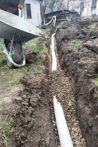 Dans la cour, les travailleurs effectuent des travaux de drainage pour le drainage de l'eau . — Photo