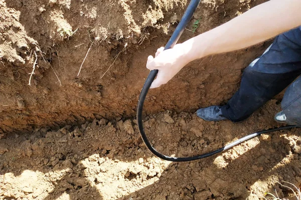 L'operaio proteggerà il cavo elettrico in trincea . — Foto Stock