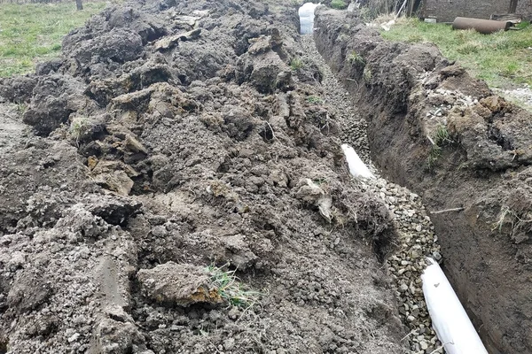 I lavoratori effettuano lavori di drenaggio per drenare l'acqua intorno alla casa . — Foto Stock