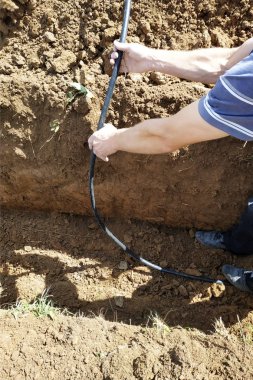 Usta bir elektrikçinin arazisine elektrik kablosu döşemek.