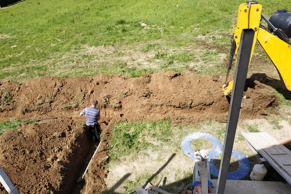 The excavator digs a trench to lay the electric cable. — Stock Photo, Image