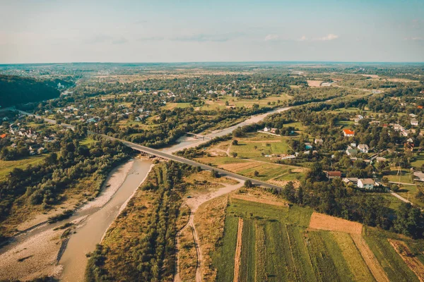 Pueblo y puente sobre la vista del río desde la cima hermosas montañas de los Cárpatos y vasto campo . —  Fotos de Stock