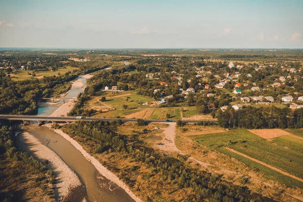 Pueblo y puente sobre la vista del río desde la cima hermosas montañas de los Cárpatos y vasto campo . — Foto de Stock