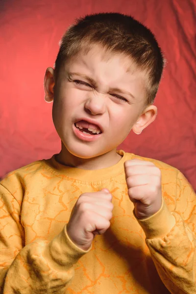 Little boy closing his eyes shows gestures signs of fighting, boxing in the studio. — Stock Photo, Image