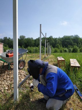 Kaynakçı köyde evin etrafında çit için yeni bir metal çerçeve kaynak.