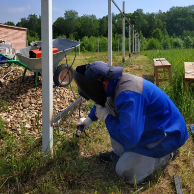 Kaynakçı köyde evin etrafında çit için yeni bir metal çerçeve kaynak.