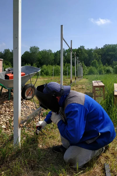 Kaynakçı köyde evin etrafında çit için yeni bir metal çerçeve kaynak.