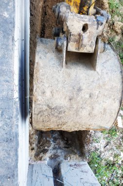 Ekskavatör bahçede küçük bir siper kazıyor..