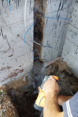 Usta bir yumruk ile demontaj yapar, duvarda bir kablo niş tire.