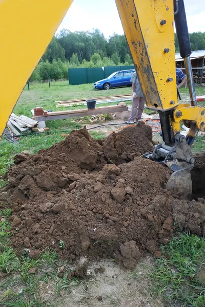 На частном участке экскаватор вырывает траншею . — стоковое фото