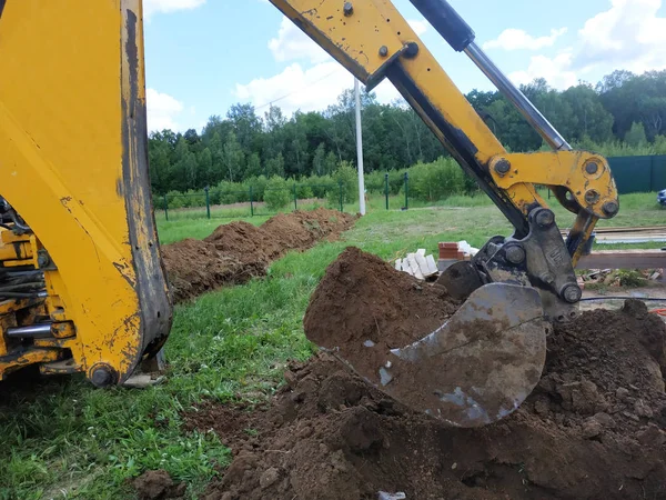In un terreno privato, l'escavatore scava una trincea . — Foto Stock