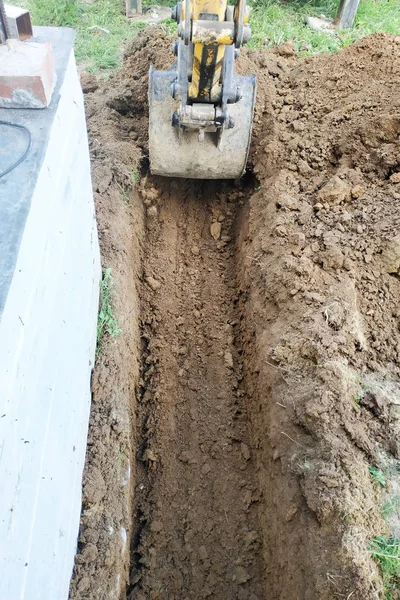 L'escavatore scava una piccola trincea nel cortile . — Foto Stock