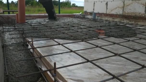 用铲子将混凝土浇筑到建筑商旁边的预制加固底座上 — 图库视频影像