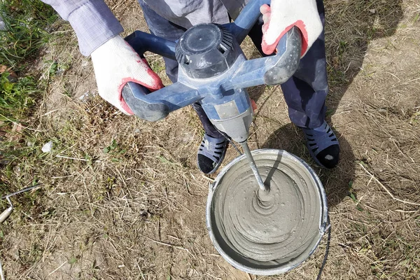 Şantiyede usta gaz bloklarıduvar döşemek için su ile tutkal karıştırır. — Stok fotoğraf