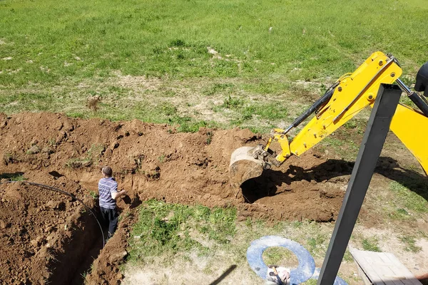 L'escavatore scava una trincea per posare il cavo elettrico . — Foto Stock