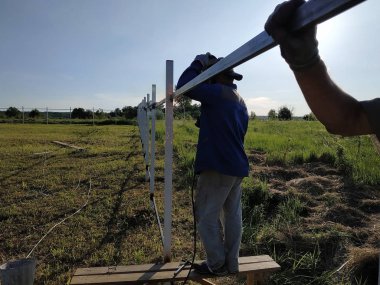 Koruyucu maske işçi kaynak çelik korkuluklar açık havada, kıvılcımlar gökyüzü ve alan arka plan karşı, aşağı sinek.