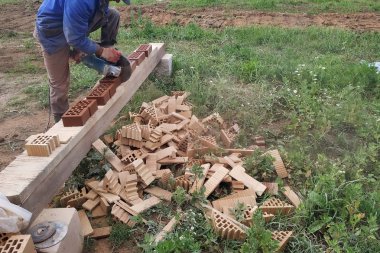 İşçi kırsal bir ön cephe tuğla ile bir köşe tuğla keser.