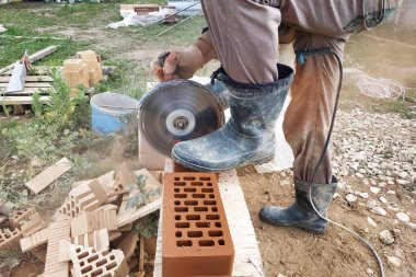 İşçi kırsal bir ön cephe tuğla ile bir köşe tuğla keser.