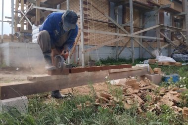 Kırsal bir bahçede bir açı öğütücü ile tuğla kesme.