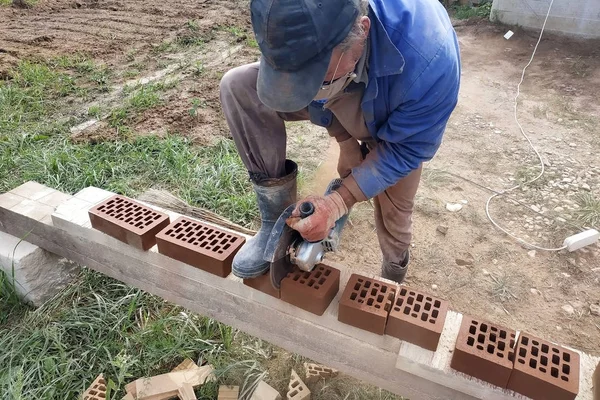 Açısal taşlama ekipmanı aracı ile bir tuğlanın kesilmesi ve öğütülmesi.