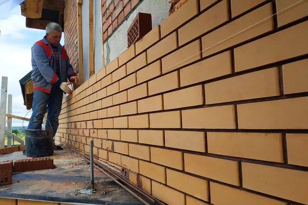 Master membangun dinding rumah dari batu bata depan. . — Stok Foto