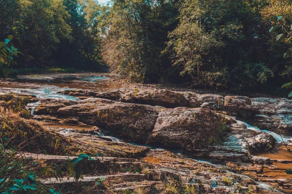 Starker Wasserlauf im Hochgebirge, umgeben von Steinen mit kleinen Moosinseln im Gewässer. — Stockfoto