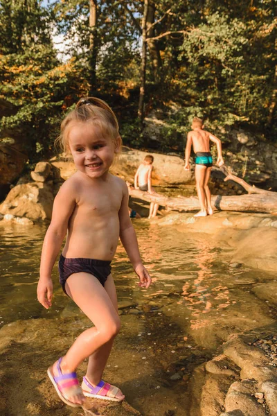 Pouco bonito linda menina nada em um rio de montanha . — Fotografia de Stock