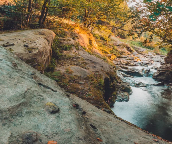 Starker Wasserlauf im Hochgebirge, umgeben von Steinen mit kleinen Moosinseln im Gewässer. — Stockfoto